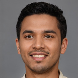 Joyful latino young-adult male with short  black hair and brown eyes