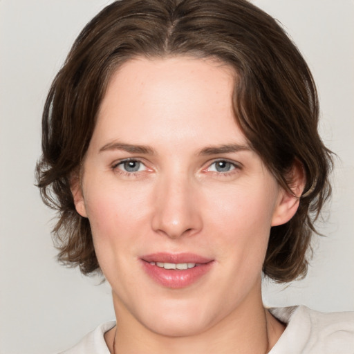 Joyful white young-adult female with medium  brown hair and blue eyes