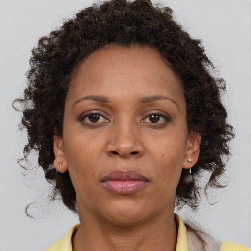 Joyful black adult female with medium  brown hair and brown eyes