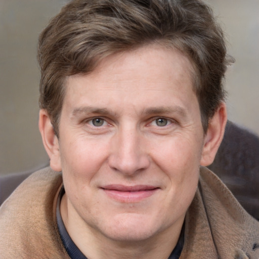 Joyful white adult male with short  brown hair and grey eyes