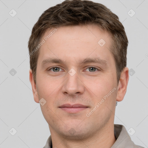 Joyful white young-adult male with short  brown hair and grey eyes