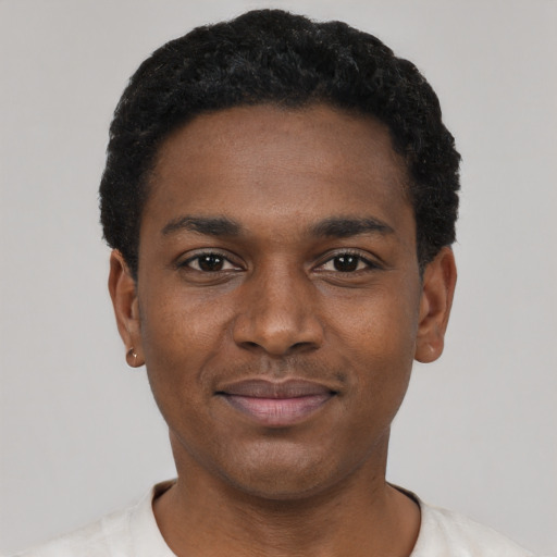 Joyful black young-adult male with short  black hair and brown eyes