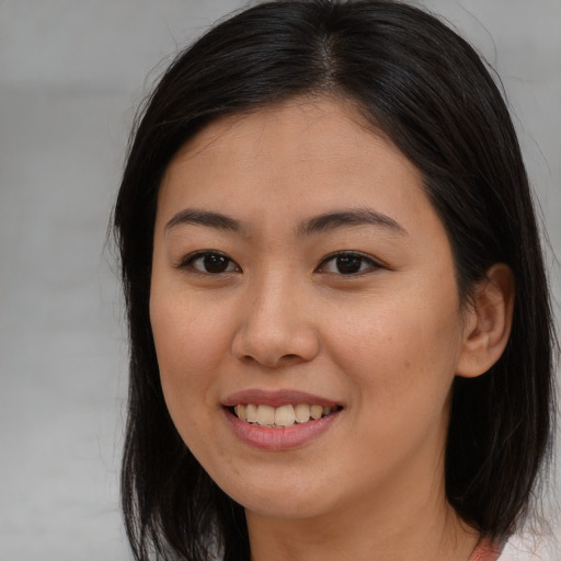 Joyful asian young-adult female with long  brown hair and brown eyes