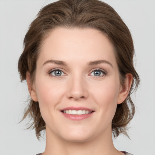 Joyful white young-adult female with medium  brown hair and grey eyes