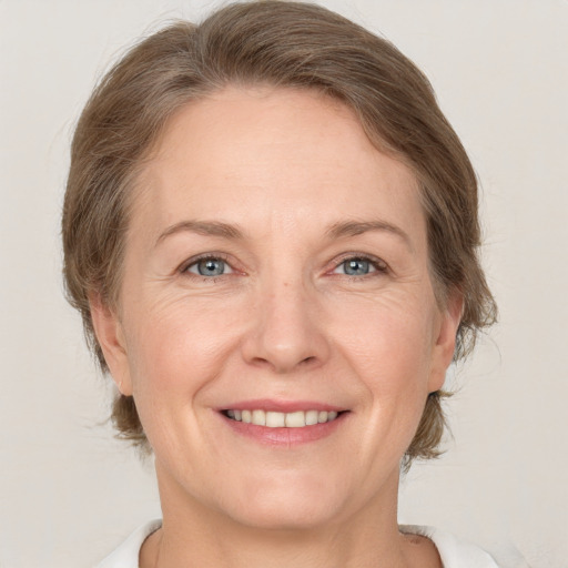 Joyful white adult female with medium  brown hair and grey eyes