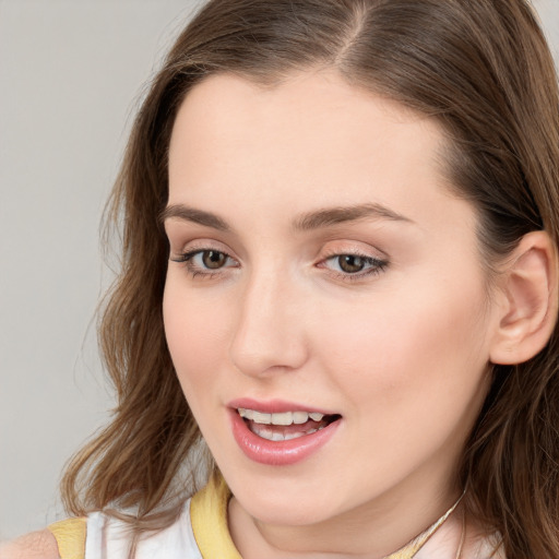 Joyful white young-adult female with long  brown hair and blue eyes