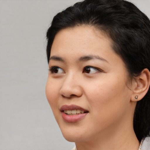 Joyful white young-adult female with medium  black hair and brown eyes
