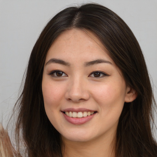 Joyful asian young-adult female with long  brown hair and brown eyes