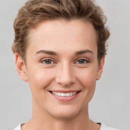 Joyful white young-adult female with short  brown hair and grey eyes