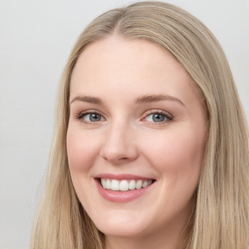 Joyful white young-adult female with long  brown hair and blue eyes