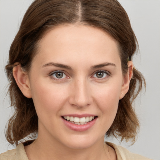 Joyful white young-adult female with medium  brown hair and grey eyes