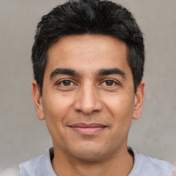 Joyful white adult male with short  black hair and brown eyes