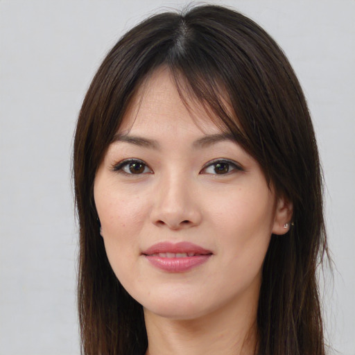 Joyful asian young-adult female with long  brown hair and brown eyes