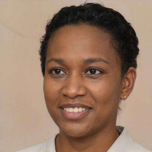 Joyful black young-adult female with short  black hair and brown eyes