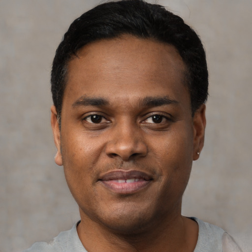 Joyful black young-adult male with short  black hair and brown eyes
