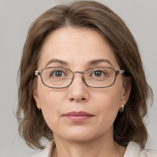 Joyful white adult female with medium  brown hair and blue eyes