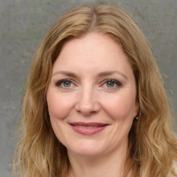 Joyful white adult female with long  brown hair and green eyes