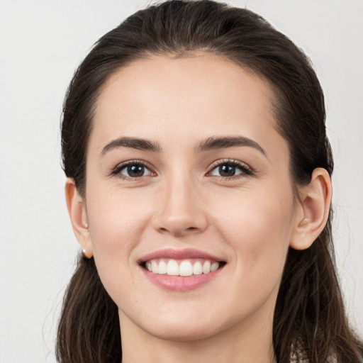 Joyful white young-adult female with long  brown hair and brown eyes