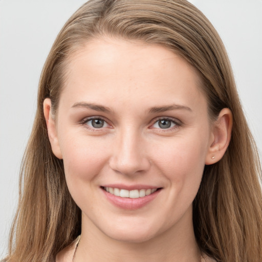 Joyful white young-adult female with long  brown hair and grey eyes