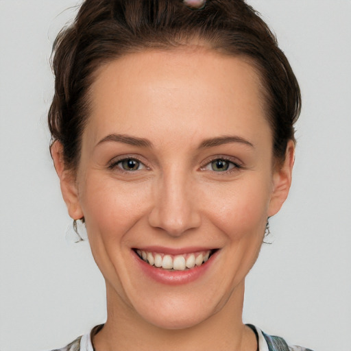 Joyful white young-adult female with short  brown hair and grey eyes