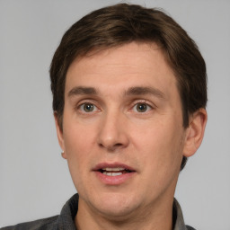 Joyful white adult male with short  brown hair and grey eyes