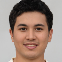 Joyful latino young-adult male with short  brown hair and brown eyes