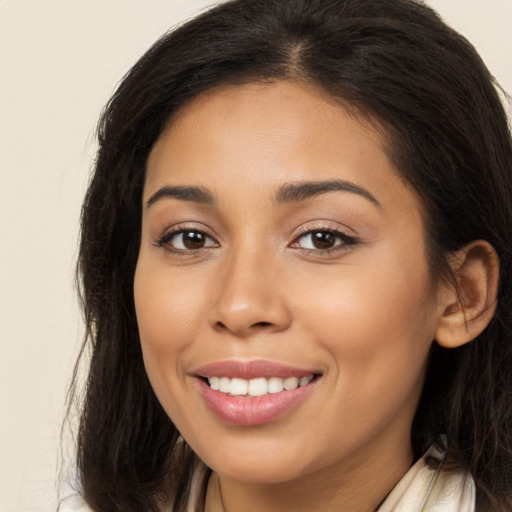 Joyful latino young-adult female with long  brown hair and brown eyes