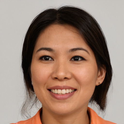 Joyful asian young-adult female with medium  brown hair and brown eyes