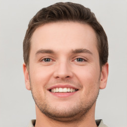 Joyful white young-adult male with short  brown hair and grey eyes