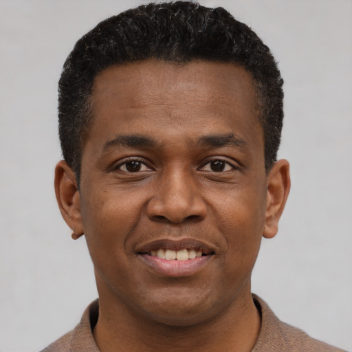 Joyful black young-adult male with short  brown hair and brown eyes