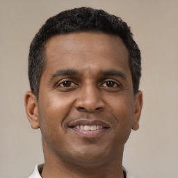 Joyful black young-adult male with short  brown hair and brown eyes