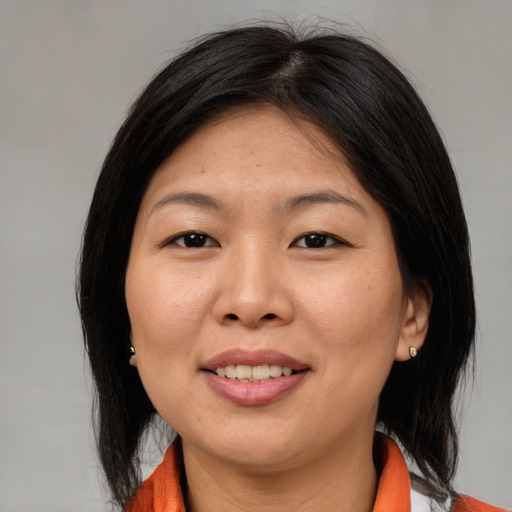 Joyful asian adult female with medium  brown hair and brown eyes