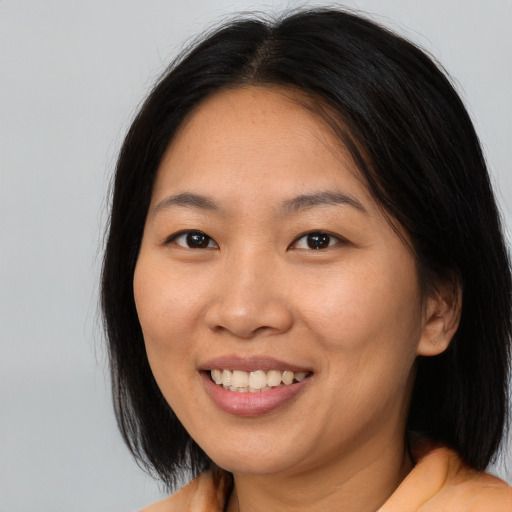 Joyful asian young-adult female with medium  brown hair and brown eyes