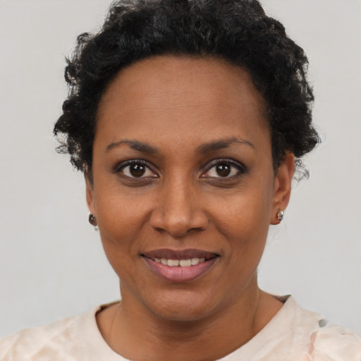Joyful black young-adult female with short  black hair and brown eyes