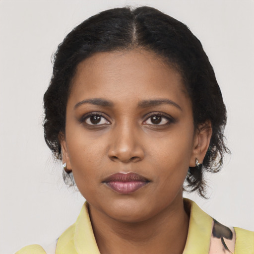 Joyful black young-adult female with short  black hair and brown eyes