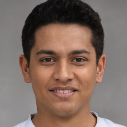 Joyful latino young-adult male with short  black hair and brown eyes