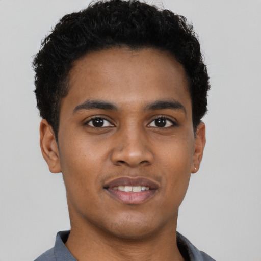 Joyful black young-adult male with short  brown hair and brown eyes