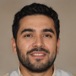 Joyful latino young-adult male with short  black hair and brown eyes