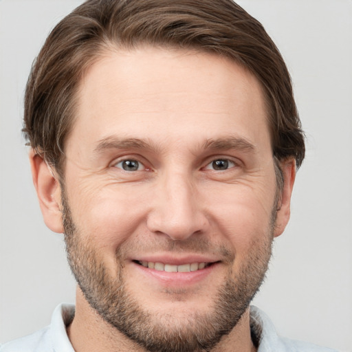 Joyful white adult male with short  brown hair and brown eyes