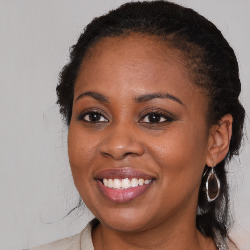 Joyful black young-adult female with medium  brown hair and brown eyes