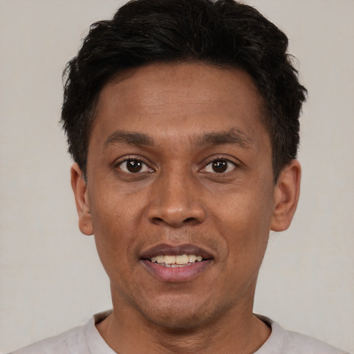 Joyful latino young-adult male with short  brown hair and brown eyes