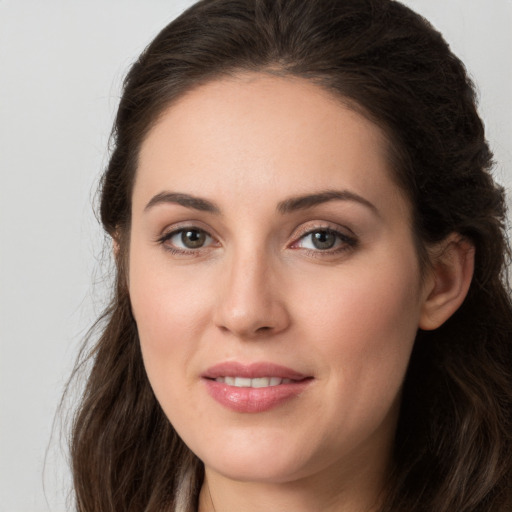 Joyful white young-adult female with long  brown hair and grey eyes