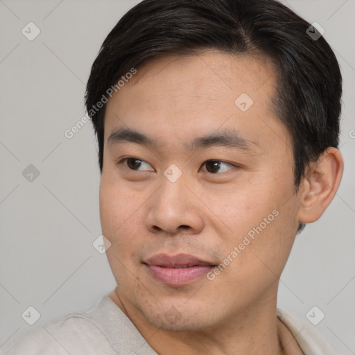 Joyful asian young-adult male with short  brown hair and brown eyes