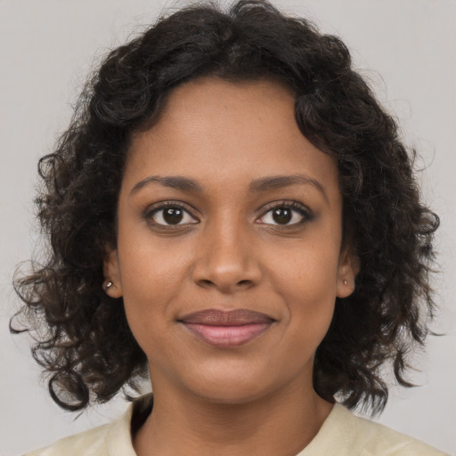 Joyful black young-adult female with medium  brown hair and brown eyes