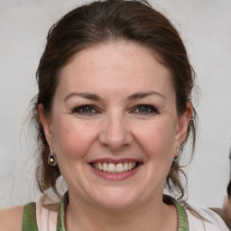 Joyful white adult female with medium  brown hair and grey eyes