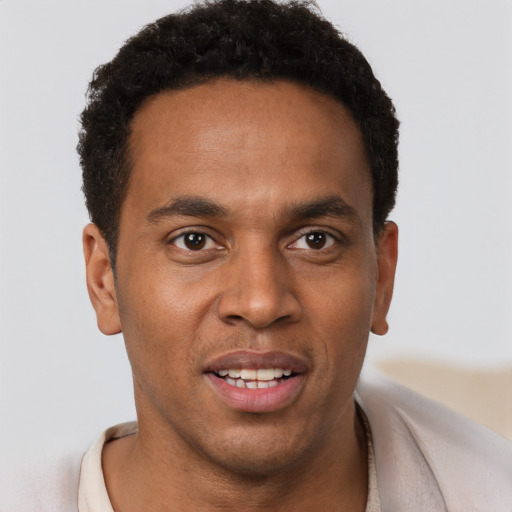 Joyful black young-adult male with short  brown hair and brown eyes