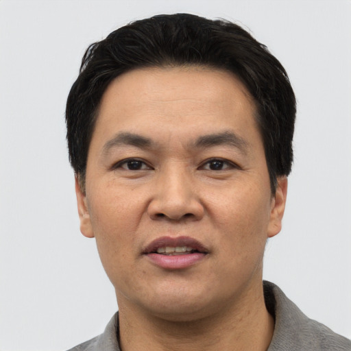 Joyful asian adult male with short  black hair and brown eyes