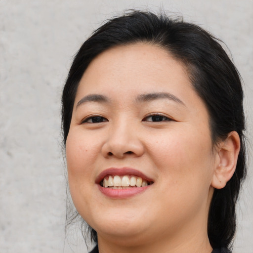 Joyful asian young-adult female with medium  brown hair and brown eyes