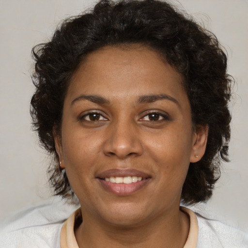 Joyful black adult female with medium  brown hair and brown eyes