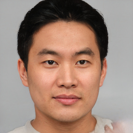 Joyful asian young-adult male with short  black hair and brown eyes
